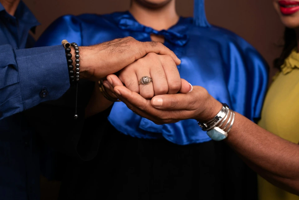 A man and woman holding hands in front of a brown background